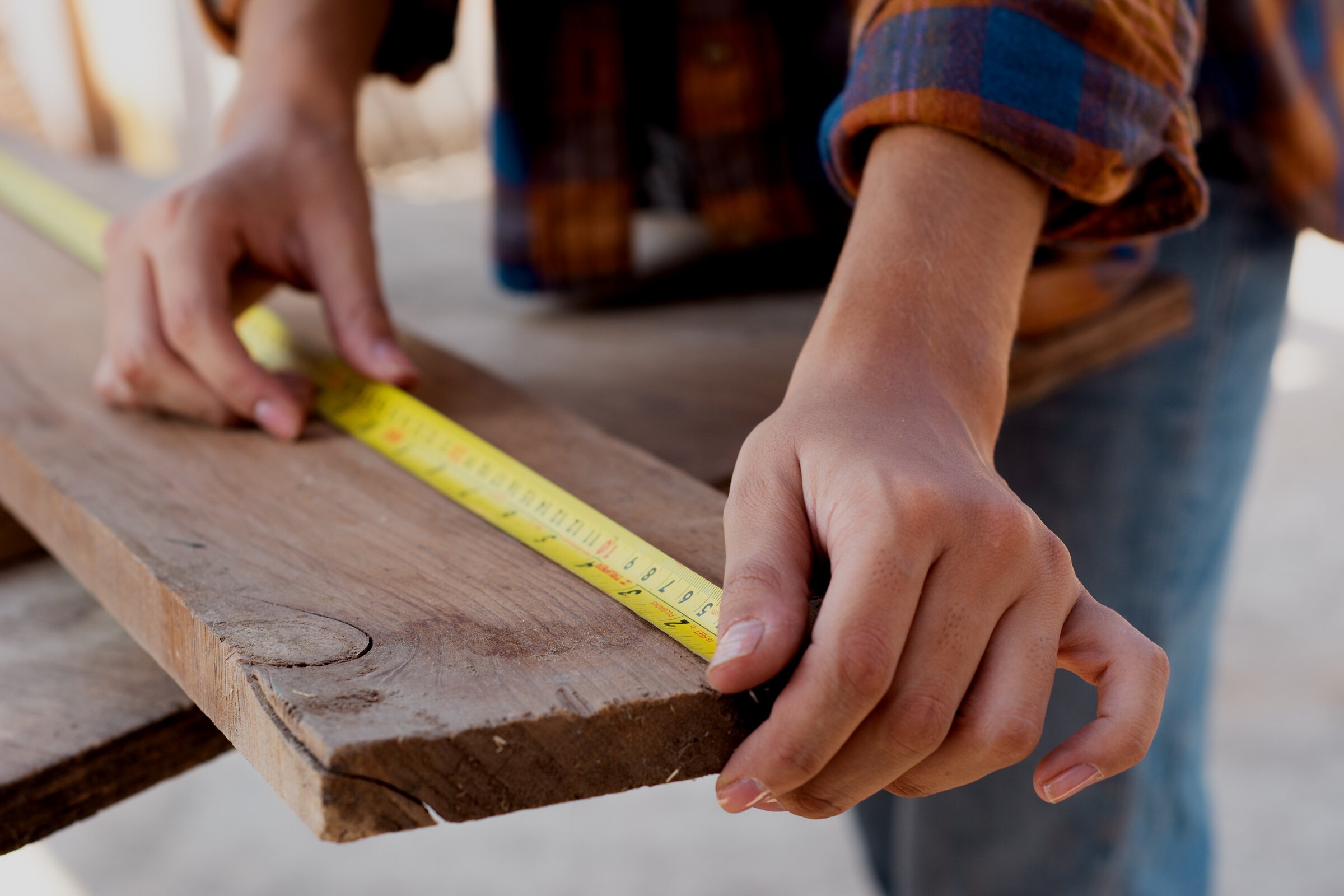 Close-Up Shot of a Carpenter Measuring a Wood Plank